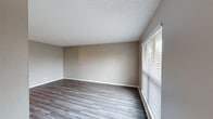 Located at 4001 Old Bullard Rd in Tyler, Texas, this single-story, 2-bedroom, 2-bathroom home offers a practical and comfortable layout with consistent design details throughout. The living room serves as a welcoming centerpiece, featuring a white-painted brick fireplace flanked by built-in shelving, a ceiling fan with light fixture, textured ceiling, and wood-look plank flooring that continues through most of the home. Natural light filters in through blinds-covered windows, brightening the neutral warm-gray walls.

The kitchen is well-equipped with white cabinetry, a white countertop with undermount sink, and black appliances including a refrigerator, electric range with double oven, and dishwasher. Light wood-look flooring adds continuity to the space.

Both bedrooms are generously sized with neutral taupe walls, wood-look flooring, and windows with blinds. Each includes a closet with hanging rods. The primary bedroom is spacious and connects to a bathroom featuring a tiled walk-in shower with sliding glass doors, grab bars, and brushed nickel fixtures. The second bathroom offers a tub-shower combo, a vanity with a quartz-style countertop, and wood-look flooring. A connecting hallway links the bedrooms and bathrooms, completing this efficient and move-in-ready floor plan.