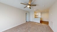 This thoughtfully designed 2-bedroom, 2-bathroom residence is laid out entirely on a single floor, offering a practical and comfortable living environment. The open-concept living room features plush wall-to-wall carpeting, a ceiling fan with integrated lighting, and recessed lighting, creating a warm and inviting atmosphere. A front entryway with a window allows natural light to filter in, enhancing the bright, neutral color palette throughout.

The kitchen is well-equipped with crisp white shaker-style cabinetry, granite-look countertops, a subway tile backsplash, a stainless steel sink, and pendant lighting over a breakfast bar peninsula. Wood-look flooring in the kitchen adds a clean contrast to the carpeted living areas.

Both bedrooms are generously proportioned with soft carpeting, ceiling fans, and ample natural light from windows fitted with blinds. The spacious primary bedroom offers comfortable dimensions, while each bedroom benefits from its own dedicated closet with wire shelving systems for organized storage.

The two bathrooms are well-appointed, each featuring a tub-shower combination with full subway tile surrounds, granite-topped vanities, and wood-look flooring. The cohesive design choices throughout — neutral tones, modern fixtures, and consistent finishes — give the entire residence a clean, move-in-ready appeal.