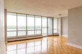 Located at 1501 Woodbine Ave in Toronto, this well-appointed one-bedroom, one-bathroom unit offers a functional and comfortable layout across a single floor. The living room is a standout space, featuring classic parquet wood flooring that extends throughout the unit and a full wall of floor-to-ceiling windows with a sliding door that opens to a balcony, flooding the room with natural light and offering expansive treetop views. The open sightlines create an airy, bright atmosphere ideal for everyday living. The kitchen has been thoughtfully updated with sleek white shaker-style cabinetry, grey quartz countertops, a grey glass tile backsplash, stainless steel sink, and modern appliances including a dishwasher, all set on neutral large-format tile flooring. The bedroom is a comfortable size, equipped with mirrored sliding closet doors and a window that frames serene green views, complemented by baseboard heating. The bathroom features a clean, contemporary design with a soaker tub and shower combination, white subway tile surround with a mosaic accent border, and coordinating quartz countertops. Neutral tones and consistent finishes throughout give the unit a cohesive, move-in-ready feel.