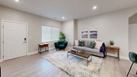 This thoughtfully designed single-floor unit offers a comfortable and functional layout across a generous footprint. The open-concept living and kitchen area serves as the heart of the space, featuring light hardwood-style flooring, recessed lighting, and a seamless flow between zones. The kitchen is outfitted with white shaker cabinetry, granite countertops, stainless steel appliances, and a large island with bar seating illuminated by three pendant lights—ideal for both cooking and casual dining.

The living area provides ample room for relaxation, with natural light filtering through windows fitted with blinds. A dedicated office with carpet flooring and a large window overlooking a green outdoor landscape offers a bright, focused workspace. The bedroom is carpeted and comfortably sized, with direct access to a walk-in closet featuring wire shelving systems. Two full bathrooms include granite vanities and tub-shower combinations. The in-unit laundry room accommodates a full-size washer and dryer alongside additional shelving and closet storage, completing this practical and well-finished layout.