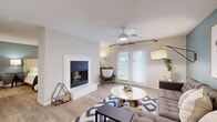 Located at 1157 Bell Road in Nashville, TN, this 2-bedroom, 1-bathroom residence offers a well-designed single-floor layout with a warm, contemporary aesthetic throughout. Light wood flooring flows seamlessly across the living spaces, complementing the neutral palette and modern finishes.

The open living room is a standout, featuring a white-framed fireplace shared with the primary bedroom, a ceiling fan, and large French doors that invite natural light and outdoor views. A teal accent wall adds a pop of color, enhancing the room's inviting ambiance.

The kitchen is thoughtfully equipped with white shaker cabinetry, quartz countertops, a white subway tile backsplash, and a full suite of stainless steel appliances including a refrigerator, dishwasher, range, and microwave. A breakfast bar with seating provides a casual dining option.

The spacious primary bedroom features its own ceiling fan and shares the cozy two-sided fireplace with the living area, creating a uniquely warm atmosphere. A closet provides dedicated storage.

The bathroom continues the teal color scheme with a white vanity, quartz countertop, and open shelving. A bright hallway connects all rooms efficiently, completing this well-appointed Nashville home.