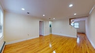 This two-floor space offers a clean, functional layout with consistent hardwood flooring that flows seamlessly throughout the living areas, lending warmth and continuity to the interior. Recessed lighting illuminates the open living spaces across both floors, creating a bright and welcoming atmosphere. The main living areas are spacious and versatile, with neutral wall tones and crisp white baseboards that complement the natural wood flooring.

The kitchen is a standout feature, outfitted with rich wood cabinetry, dark granite countertops, a tile backsplash, and a full suite of stainless steel appliances including a gas range, microwave, dishwasher, and refrigerator. A peninsula with a breakfast bar counter provides additional prep and seating space, while tile flooring and crown molding add a polished finishing touch. Natural light enters through a window with blinds, and a charming door with decorative glass panels provides access.

The bathroom is tastefully finished with large-format tile walls accented by a mosaic tile border in warm earth tones, a pedestal sink, and a mirrored medicine cabinet. Additional rooms throughout the space offer generous square footage, with windows bringing in natural light and baseboard heating ensuring year-round comfort. A staircase connects the two floors, making the overall layout practical and well-organized.