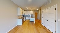 This contemporary apartment in Fargo, North Dakota, showcases a thoughtfully designed open-concept layout. The heart of the space is a modern kitchen featuring crisp white cabinetry, stainless steel appliances, and a practical island. Pendant lights add a touch of elegance, while recessed lighting ensures ample illumination throughout.

The living area seamlessly connects to the kitchen, boasting hardwood floors that extend throughout the main living spaces. A sliding glass door leads to a balcony, providing natural light and outdoor access.

The bathroom is well-appointed with a single vanity, large mirror, and a combination tub-shower. Light wood flooring adds warmth to the space, complemented by modern fixtures and ample storage.

The bedroom presents an industrial-chic aesthetic with exposed ductwork and a large window offering city views. Carpeted flooring adds comfort underfoot.

Throughout the apartment, neutral tones create a calming atmosphere, while the open floor plan and strategic lighting contribute to a sense of spaciousness. This single-floor unit at 320 11th St N combines style and functionality, perfect for contemporary urban living.