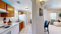 Located at 435 Ithaca Ct in Las Cruces, NM, this single-story, 2-bedroom, 4-bathroom home offers a practical and comfortable layout across a well-utilized floor plan. The galley-style kitchen is equipped with rich wood cabinetry, white appliances including a range, dishwasher, and refrigerator, and light tile flooring with ample counter space on both sides. An arched passageway connects the kitchen to the main living areas, lending a classic Southwestern architectural touch. The living room is an open, inviting space featuring carpet flooring, a ceiling fan, and an arched opening that enhances the sense of flow throughout the home. The dining area benefits from large windows on two walls, flooding the space with natural light and offering views of the surrounding greenery. Both bedrooms are generously proportioned, carpeted, and include ceiling fans and windows. The primary bedroom is notably spacious, providing ample room for a full furniture arrangement. The four bathrooms feature tile flooring, wood vanity cabinetry, and clean, functional fixtures. Two hallways connect the rooms efficiently, and a dedicated closet adds valuable storage. The textured ceilings and neutral warm tones throughout create a cohesive, comfortable ambiance suited to everyday living in the Las Cruces community.