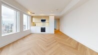 Located in the heart of Toronto's financial district at 158 Pearl St, this thoughtfully designed 3-bedroom, 2-bathroom unit delivers a clean, modern aesthetic across a single floor. Signature light oak herringbone hardwood flooring flows consistently throughout every room, lending a sense of warmth and sophistication to the bright, white interior.

The open living area is a standout, featuring wraparound floor-to-ceiling windows that frame sweeping panoramic views of the Toronto skyline and Lake Ontario beyond. A sleek, integrated kitchen sits adjacent, outfitted with two-tone cabinetry in white and warm wood tones, built-in appliances including a wall oven and microwave, and a large window that further floods the space with natural light.

Each of the three bedrooms continues the herringbone flooring and crisp white walls, with large windows offering city views. The primary bedroom includes a sliding frosted-glass closet, while additional bedrooms provide generous proportions and ample natural light.

The two bathrooms are finished to a high standard. The main bathroom features soft blue vertical tile, a soaking tub with a matte black shower system, a dark floating vanity, and a backlit mirror. The second bathroom echoes the same refined palette with terrazzo-style flooring, a sleek dark vanity, and an illuminated mirror cabinet. Black hardware accents throughout tie the design together cohesively.