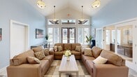 Located at 1909 104 Ave E in Edgewood, Washington, this single-story community amenity building offers a diverse range of gathering and recreational spaces designed to serve residents across multiple functional areas.

The central lounge area is an inviting, light-filled space anchored by soaring vaulted ceilings and a bank of large windows with transom panes above, allowing abundant natural light to filter in while offering views of the surrounding neighborhood. Soft blue walls, pendant lighting, and comfortable seating arrangements create a warm, welcoming atmosphere. An adjacent bar-height counter with stools runs along the windowed wall, providing a casual workspace or social area.

The fitness room features high ceilings, mirrored walls, and access to additional rooms, making it a versatile exercise space. Connecting corridors display a distinctive patterned tile flooring and lead to various wings of the building, including a large, high-ceilinged pool or multipurpose area with industrial-style ventilation and clean white finishes.

The standout game room energizes the building with bold, multicolored walls in purple, orange, green, and blue, complemented by vibrant patterned carpeting. It is equipped with a pool table, foosball table, arcade-style interactive games, and pop art décor, creating a lively entertainment destination.