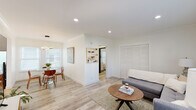 Located at 1828 N Edgemont St in the desirable Los Feliz neighborhood of Los Angeles, this single-floor unit offers a thoughtfully designed layout with a clean, modern aesthetic throughout. Light wood-look flooring, crisp white walls, and crown molding create a cohesive and polished look from room to room.

The open-concept living and dining area is bathed in natural light from multiple windows dressed with white slatted blinds. The living space features a comfortable sectional sofa, recessed lighting, and a large louvered closet, while the dining nook is anchored by a round glass-top table and a striking sculptural pendant light, adding a contemporary focal point to the space.

The kitchen stands out with its two-tone cabinetry — white upper shaker cabinets paired with bold navy blue lower cabinets — complemented by a classic white subway tile backsplash, light countertops, stainless steel appliances, and sleek track lighting overhead.

The bedroom is bright and tranquil, featuring large windows that invite natural light and provide a calm retreat. The bathroom offers an elegant touch with dramatic marble-style wall tile and matte black fixtures, blending modern design with timeless sophistication.
