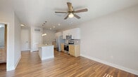 This well-appointed one-bedroom, one-bathroom residence in Orlando, Florida offers a thoughtfully designed single-floor layout with modern finishes throughout. The kitchen serves as a standout feature, showcasing a two-tone cabinetry design with crisp white upper cabinets and warm wood-toned lower drawers, granite-look countertops, and a suite of stainless steel appliances including a French door refrigerator, electric range, and microwave. A central island with an undermount sink and stylish pendant lighting adds both functionality and visual appeal, while wood-look flooring ties the space together seamlessly. The living area is bright and welcoming, featuring a ceiling fan and a large window that invites natural light and outdoor views. The bedroom is a comfortable retreat finished with plush carpeting, multiple windows with blinds, and a ceiling fan, creating a serene and airy atmosphere. A dedicated closet provides practical storage. The bathroom is finished in a clean, contemporary style with vertical subway tile surrounding the soaking tub and shower, wood-look flooring, a wood-toned vanity with granite countertops, and brushed nickel fixtures. The overall design balances modern aesthetics with everyday functionality, making this Orlando residence a polished and comfortable space.