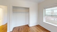 Located at 518 S 7th St in Tacoma, Washington, this one-bedroom, one-bathroom unit offers a functional and efficiently designed layout across a single floor. Rich hardwood flooring runs throughout the living spaces, lending warmth and character to the interior. The living room is bright and welcoming, featuring a classic cast-iron radiator and a window that draws in natural light. The kitchen is equipped with white cabinetry, butcher block countertops, and an electric range, offering a clean and practical cooking space. The bedroom is a comfortable size, featuring its own window with views of the surrounding Tacoma streetscape, a ceiling fan, and a full-width closet with a hanging rod and shelf for ample storage. The bathroom is well-appointed with classic penny tile flooring, a white vanity with cabinet storage, a medicine cabinet mirror with overhead lighting, and a shower-over-tub combination. A dedicated laundry area adds everyday convenience. The unit's crisp white walls and natural wood floors create a clean, neutral aesthetic throughout. A hallway connects the rooms cohesively, making the overall layout feel organized and easy to navigate.