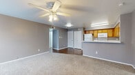 This single-floor, 3-bedroom, 2-bathroom unit in Austin, TX (78753) offers a functional and well-organized layout ideal for comfortable everyday living. The open-concept living and dining area features neutral gray walls, plush carpet, and a ceiling fan with light fixture, creating a welcoming atmosphere. Wood-look flooring transitions seamlessly into the kitchen area, adding warmth and visual contrast.

The kitchen is equipped with warm-toned wood cabinetry, white appliances including a refrigerator, range, and microwave, and a peninsula countertop that provides additional prep space and separates the kitchen from the living area. A stainless steel sink is integrated into the peninsula for added convenience.

Each of the three bedrooms is carpeted and features neutral wall tones, blinds-covered windows that bring in natural light, and ceiling fans in select rooms. The primary bedroom includes a walk-in closet with built-in shelving, offering generous storage. Additional bedrooms also feature dedicated closet space.

Both bathrooms are finished consistently with wood-look flooring, warm wood vanities with white countertops, large mirrors, and tub-shower combinations with white tile surrounds. The overall design is clean, practical, and move-in ready, making this unit a solid choice in the Austin area.