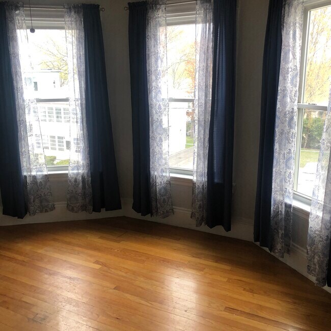 Sala de estar con ventanales y piso de madera. - 203 6th St