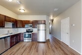 Located at 1109 Honeysuckle Dr in Harrisburg, South Dakota, this two-story home offers 2 bedrooms and 3 bathrooms across two well-proportioned floors. The main level features an open-concept layout that seamlessly connects the living room, dining area, and kitchen. The living room is finished with light wood-look flooring and includes a sliding glass door that invites natural light and provides outdoor access. The kitchen is equipped with rich dark-wood cabinetry, a tile backsplash, light countertops, and a full suite of stainless steel appliances, including a refrigerator, range, and microwave. A carpeted staircase with a white railing leads to the upper level, where both bedrooms are found. The spacious primary bedroom features plush carpeting and a window with neighborhood views. The second bedroom is similarly finished with carpet and a bright window. Three bathrooms throughout the home include vanities with dark wood cabinetry and white countertops. A dedicated laundry room houses a full-size washer and dryer with overhead shelving. The attached garage features an automatic opener and provides convenient interior access. Four closets throughout the home offer ample storage. Neutral-toned walls and consistent finishes create a cohesive, move-in-ready aesthetic throughout.