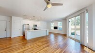 Located at 25 Whistler Court in Saratoga Springs, NY, this thoughtfully designed single-floor residence offers two bedrooms and two bathrooms across a well-appointed floor plan. The open-concept living and kitchen area is anchored by warm hardwood flooring, recessed lighting, and a ceiling fan, creating a bright and inviting atmosphere. Sliding glass doors lead to a private balcony, filling the space with natural light and offering outdoor views. The kitchen is outfitted with crisp white cabinetry, subway tile backsplash, stainless steel appliances, a gas range, and a central island with pendant lighting — ideal for both cooking and entertaining. The spacious primary bedroom features soft carpeting, a ceiling fan, and ample room to relax. The second bedroom is equally comfortable, with a large window overlooking greenery. The bathrooms are finished with classic penny tile flooring; one features a walk-in shower with a bold black-framed glass enclosure, while the other includes a soaking tub. A dedicated in-unit laundry area with a stacked Whirlpool washer and dryer adds everyday convenience. Two hallways connect the rooms efficiently, completing this clean, modern home.