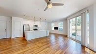 Located at 25 Whistler Court in Saratoga Springs, NY, this thoughtfully designed single-floor residence offers two bedrooms and two bathrooms across a well-appointed floor plan. The open-concept living and kitchen area is anchored by warm hardwood flooring, recessed lighting, and a ceiling fan, creating a bright and inviting atmosphere. Sliding glass doors lead to a private balcony, filling the space with natural light and offering outdoor views. The kitchen is outfitted with crisp white cabinetry, subway tile backsplash, stainless steel appliances, a gas range, and a central island with pendant lighting — ideal for both cooking and entertaining. The spacious primary bedroom features soft carpeting, a ceiling fan, and ample room to relax. The second bedroom is equally comfortable, with a large window overlooking greenery. The bathrooms are finished with classic penny tile flooring; one features a walk-in shower with a bold black-framed glass enclosure, while the other includes a soaking tub. A dedicated in-unit laundry area with a stacked Whirlpool washer and dryer adds everyday convenience. Two hallways connect the rooms efficiently, completing this clean, modern home.
