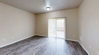Located at 10436 SE Carr Rd in Renton, WA, this well-appointed two-bedroom, two-bathroom residence offers a practical and comfortable single-floor layout. The combined living and dining area is bright and open, featuring durable wood-style vinyl flooring and sliding glass doors that lead to a private balcony, bringing in natural light and outdoor access. The kitchen is efficiently designed in a galley style, outfitted with warm medium-toned wood cabinetry, white countertops, stainless steel appliances including a refrigerator and microwave, and a black electric range. A peninsula counter provides additional workspace and separation from the living area. A separate pantry offers generous storage. Both bedrooms are carpeted and feature neutral walls, windows with exterior views, and good natural light. The spacious primary bedroom includes its own closet. The two bathrooms are finished with wood-style flooring, neutral beige walls, chrome fixtures, and grab bars for accessibility. One bathroom features a full tub/shower combination. Additional highlights include in-unit laundry, multiple closets for storage, and a hallway connecting the private quarters. The consistent neutral color palette and clean finishes create a cohesive, move-in-ready atmosphere throughout.