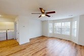 Located at 101 Whitsell Way in Pontoon Beach, IL, this two-bedroom, one-bathroom single-story home offers a well-designed layout that maximizes functionality and comfort. The open-concept kitchen and living area serves as the heart of the home, featuring warm hardwood-style flooring that flows throughout the entire space. The kitchen is well-appointed with white shaker-style cabinetry, granite countertops, a central island for additional prep and dining space, and a full suite of stainless steel appliances including a refrigerator, range, microwave, and dishwasher. Recessed lighting adds a clean, modern touch overhead. The living area is bright and welcoming, highlighted by a large bay-style window that draws in generous natural light and a ceiling fan with integrated lighting. Both bedrooms continue the hardwood-style flooring and are each equipped with ceiling fans and windows that allow natural light in. The spacious primary bedroom offers comfortable proportions with ample room for furnishings. The bathroom includes a full tub-shower combination with built-in shelving. Additional practical spaces include a laundry area, pantry, utility room, and three closets, ensuring excellent storage throughout the home.
