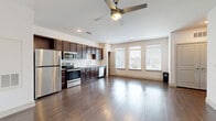 Located in San Antonio, TX, this two-story, one-bedroom, one-bathroom home offers a well-designed layout across two floors. The ground level houses an attached garage with automatic opener, a utility room, and a dedicated laundry area complete with a full-size washer and dryer. A staircase leads to the main living floor above, where the majority of the home's space is concentrated.

The upper level opens into a bright, open-concept area combining the living room, dining room, and kitchen. The kitchen is outfitted with rich dark-wood cabinetry, a herringbone-patterned tile backsplash, granite-style countertops, and a full suite of stainless steel appliances including a refrigerator, range, microwave, and dishwasher. Wide-plank hardwood-style flooring runs throughout, and a ceiling fan with integrated lighting anchors the living space. Multiple windows fitted with blinds allow generous natural light to fill the room.

The bedroom is a comfortable, well-proportioned retreat featuring its own ceiling fan, hardwood-style floors, and a window with an outdoor view. Two closets provide ample storage. The full bathroom includes a dark-wood vanity with granite countertop, a walk-in shower with sliding glass doors, and hardwood-style flooring. A private patio and fenced yard round out this home's thoughtful amenities.