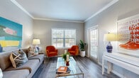 Located at 11800 City Park Central Ln in Houston, TX, this one-bedroom, one-bathroom residence offers a thoughtfully designed single-floor layout that maximizes both function and comfort. The open-concept living, dining, and kitchen area serves as the heart of the home, featuring durable wood-style flooring, crown molding, and an abundance of natural light streaming through large windows fitted with blinds. The living room provides generous space for relaxing and entertaining, with direct access to a private balcony. The kitchen is well-equipped with white shaker cabinetry, granite countertops, a classic tile backsplash, and stainless steel appliances, including a range, microwave, and refrigerator. A dedicated dining nook adjacent to the kitchen offers a defined space for meals. The bedroom is carpeted for comfort, features a walk-in closet, and includes a window with outdoor views. The bathroom continues the home's refined aesthetic with white cabinetry, granite countertops, a framed mirror, and wood-style flooring. Additional highlights include in-unit laundry, three closets for ample storage, and a hallway connecting the private areas of the home seamlessly.