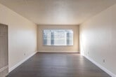 Located at Palm Ave in Marina, California, this 2-bedroom, 1-bathroom single-story unit offers a clean, functional layout designed for comfortable everyday living. The living room features light hardwood-style flooring, a textured ceiling, and a large window fitted with horizontal blinds that fills the space with natural light, creating an open and airy feel. The kitchen is well-appointed with warm wood cabinetry, granite-style countertops, a peninsula island for additional prep space, and white appliances including a range, dishwasher, and refrigerator — all set on light hardwood-style flooring. Both bedrooms are finished with hardwood-style flooring and neutral walls, with windows that allow natural light to brighten each room. The primary bedroom offers a comfortable footprint with closet access. The bathroom includes a wood-vanity with a granite countertop, an undermount sink, a large mirror, and a full tub-shower combo with sliding glass doors — all finished with consistent warm wood tones. A dedicated utility room, hallway, and two closets round out the practical layout. The unit's consistent neutral palette and natural light give the interior a tidy, move-in-ready character.