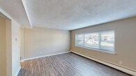 Located at 5 Nob Hill Rd in New London, Connecticut, this 2-bedroom, 1-bathroom unit offers a practical and well-organized single-floor layout. The combined kitchen and living area serves as the heart of the home, with the kitchen featuring rich dark-stained cabinetry, granite-style countertops, and a full suite of stainless steel appliances including a refrigerator, dishwasher, and range. Light wood-tone vinyl flooring runs through the kitchen, living area, and entryway hallway, lending a clean and cohesive look.

The living room receives natural light through a wide multi-pane window with outdoor views, and baseboard heating is present throughout the unit. Both bedrooms are comfortably sized, carpeted in neutral tones, and each features a window that brings in natural light, along with baseboard heaters. The primary bedroom is notably spacious, offering ample room for standard furniture arrangements.

The bathroom is finished in white with a tub and shower combination, a window for ventilation and light, and a dark-stained vanity that complements the kitchen cabinetry. A hallway connects the main living spaces to the bedrooms and bathroom, contributing to an efficient and well-defined floor plan throughout the unit.