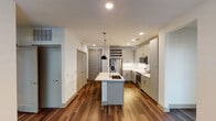 Located at 315 S Calhoun St in Fort Worth, Texas, this single-floor unit offers a contemporary design with thoughtful finishes throughout. The open-concept kitchen serves as the heart of the space, featuring gray shaker-style cabinetry extending to the ceiling, white quartz countertops, a white subway tile backsplash, and a full suite of stainless steel appliances including a French door refrigerator, electric range, and over-the-range microwave. A central island with an integrated sink and pendant lighting above adds both functionality and style. A built-in wine rack provides additional character. Rich hardwood-style flooring flows through the main living and kitchen areas, creating a warm, cohesive aesthetic.

The bedrooms offer plush carpeting underfoot and are each equipped with ceiling fans and windows fitted with blinds, allowing natural light while maintaining privacy. The bathrooms are finished with large-format tile flooring, gray vanity cabinetry, white quartz countertops, and tub-shower combinations with tile surrounds. Walk-in closets with built-in shelving and hanging systems provide generous, organized storage. The overall design balances modern aesthetics with practical functionality throughout.