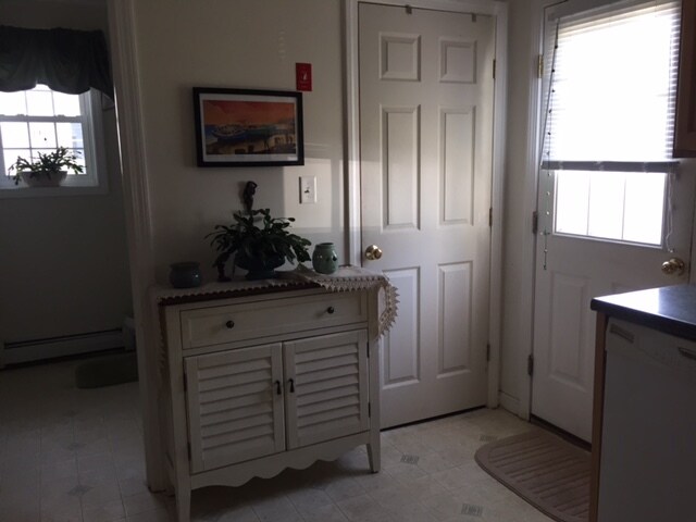 Kitchen area with backdoor to the right and downstairs bathroom to the left, storage through the door to the right of the cabinet. - 40 Government St