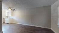Located at 1501 Kinney Ave in Austin, TX, this single-story unit offers a straightforward, functional layout with consistent finishes throughout. Dark hardwood-style flooring runs across the main living areas and bedroom, providing a cohesive look that contrasts cleanly with the neutral gray walls and bright white baseboards. The spacious living area features a textured popcorn ceiling and a ceiling fan, keeping the space comfortable year-round. Natural light filters in through windows, complementing the open feel of the room.

The kitchen is well-equipped with stainless steel appliances, including an electric range and a full-size refrigerator, set against white cabinetry with updated hardware. A tile backsplash adds a subtle design detail, while a window above the counter area brings in additional natural light. A peninsula-style counter separates the kitchen from the living space, creating a natural transition between the two areas.

The bathroom is clean and efficiently designed, featuring a white vanity with a light countertop, a full tub and shower combo with built-in shelving, and a small window that provides ventilation and natural light. The wood-style flooring carries through into this space as well, maintaining visual continuity. Overall, the unit presents a clean, move-in ready environment in a well-known Austin neighborhood.