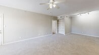 This well-appointed 2-bedroom, 2-bathroom single-floor residence at 800 Lakeside Cir in Lewisville, TX offers a thoughtfully designed layout with a seamless blend of functionality and comfort. The entryway opens into a combined kitchen and living area, where wood-look flooring flows through the kitchen and transitions to plush carpeting in the living space. The kitchen features gray cabinetry, white appliances, a tile backsplash, and a breakfast bar that connects to the main living area. The spacious living room is highlighted by a classic fireplace, a ceiling fan, crown molding, and a sliding glass door that leads to an outdoor area with natural views. The generously sized primary bedroom includes a ceiling fan, built-in shelving, and access to a walk-in closet with wire shelving systems. The second bedroom also features plush carpet and a ceiling fan. Each bathroom is distinctly appointed — one includes a soaking tub with tiled surround and gray cabinetry, while the other offers a modern frameless glass walk-in shower with marble-style tile. Both bathrooms feature wood-look flooring and white countertops. A dedicated utility room and ample closet space round out this practical and comfortable home.