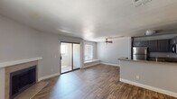This single-floor residence offers a well-designed, open-concept layout that seamlessly connects the living, dining, and kitchen areas. The main living space is finished with durable wood-look flooring and painted in neutral tones, creating a clean and inviting atmosphere throughout. A ceiling fan with a light fixture provides both comfort and illumination to the living area, which also features a corner fireplace with a tiled hearth — an ideal focal point for the room. Natural light flows in through a large sliding glass door that opens to an outdoor patio, as well as through additional windows fitted with blinds for privacy and light control.

The kitchen is thoughtfully appointed with gray shaker-style cabinetry, granite-look countertops, and a full suite of stainless steel appliances, including a refrigerator, range, microwave, and dishwasher. A peninsula with a built-in sink extends into the living area, offering additional prep space and a casual dining option.

The bedroom features plush carpeting, soft neutral walls, and a closet, offering a comfortable and quiet retreat. The bathroom includes a granite-look vanity countertop, a full tub-and-shower combination with clean white tile surround, and a large mirror. The textured ceilings and consistent design choices throughout give the space a cohesive, well-maintained character.