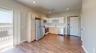 Located on Goldfinch in Lincoln, NE, this single-floor, one-bedroom, one-bathroom unit offers a thoughtfully designed open-concept layout that maximizes its efficient footprint. The kitchen is a standout feature, equipped with a full suite of stainless steel appliances — including a refrigerator, electric range, microwave, and dishwasher — complemented by a combination of white shaker-style and natural light wood cabinetry, light countertops, and wood-look plank flooring that flows seamlessly throughout the space. The kitchen connects directly to the living area, which is bright and airy thanks to multiple windows that invite ample natural light. Sliding glass doors lead to a private balcony, offering pleasant outdoor views of the surrounding landscape. The bedroom is a well-sized, serene retreat with additional windows providing continued natural light and outdoor views. A dedicated closet provides convenient storage. The bathroom features a clean, all-white walk-in shower. Neutral gray wall tones, white trim, and consistent wood-look flooring throughout lend the space a cohesive, modern aesthetic. A dedicated closet adds practical storage to round out this functional and attractive unit.