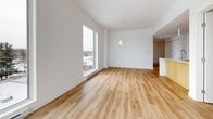 Located at 256 Boulevard St-Raymond in Gatineau, Quebec, this modern 3-bedroom, 2-bathroom unit offers a thoughtfully designed open-concept layout finished with consistent light hardwood flooring throughout. The combined living and kitchen area forms the heart of the home, bathed in natural light through large floor-to-ceiling windows that frame views of the surrounding neighbourhood. The contemporary kitchen is a standout feature, equipped with sleek white cabinetry extending to the ceiling, a white subway tile backsplash, stainless steel appliances, and a two-tone island with a white quartz countertop and warm wood panelling — ideal for both meal preparation and casual dining. Each of the three bedrooms is bright and well-proportioned, benefiting from generous windows and a clean, minimalist aesthetic with white walls and light flooring. The primary bedroom includes access to a dedicated ensuite bathroom featuring a glass-enclosed shower stall and a warm wood vanity. The second full bathroom is finished with large-format white tiles and offers a soaker tub with an integrated shower. A dedicated closet provides additional storage. The unit also features a wall-mounted air conditioning unit and baseboard heating throughout, ensuring year-round comfort.