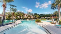 Located at 4600 Portofino Way in West Palm Beach, Florida, this outdoor amenity space captures the essence of resort-style living in South Florida. The centerpiece is a generously sized, freeform lagoon pool with crystal-clear turquoise water that winds through a beautifully landscaped setting. The pool's organic, curved design creates a relaxed, tropical atmosphere reminiscent of a luxury resort destination.

Surrounding the pool, a broad, light-toned paved deck provides ample space for lounging, lined with teal-accented chaise lounge chairs and shaded by pergolas and large umbrellas. Lush tropical landscaping — including tall swaying palm trees, manicured shrubs, and tropical plantings — frames the space, offering both visual appeal and natural shade.

In the background, the Mediterranean-inspired residential architecture features warm stucco facades with terracotta-accented rooflines, complementing the overall Portofino-themed aesthetic. The open sky above floods the entire area with abundant natural Florida sunshine, enhancing the bright, inviting ambiance. This outdoor space offers a tranquil, resort-caliber retreat ideal for relaxation and recreation, set within the vibrant community of West Palm Beach.