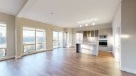 Located in the heart of Kansas City's Crossroads district, this well-appointed 2-bedroom, 2-bathroom residence offers a thoughtfully designed open-concept layout filled with natural light. Wide-plank hardwood flooring flows throughout the main living areas, anchored by a striking granite-surround fireplace and floor-to-ceiling windows that frame expansive urban skyline views with access to a private balcony.

The contemporary kitchen is a standout, featuring sleek flat-front cabinetry with frosted glass uppers, granite countertops, a decorative tile backsplash, a built-in cooktop, double wall ovens, and a central island with a sink — ideal for both everyday cooking and entertaining.

The primary bedroom offers generous proportions, plush carpeting, large windows with city views, and a sophisticated en-suite bathroom complete with a glass-enclosed walk-in shower, tiled flooring, an LED-lit medicine cabinet, and a vessel sink vanity. The second bedroom is equally comfortable, featuring mirrored closet doors and soft carpeting. The second full bathroom includes a soaking tub, chevron-patterned tile flooring, and a clean white vanity with LED mirror. The building exterior showcases a modern multi-story design with a landscaped courtyard and rooftop amenity space.