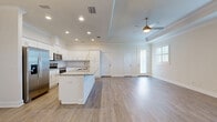 Located at 11225 Linden Dr in Spring Hill, FL, this well-designed single-story home offers 2 bedrooms and 2 bathrooms across a thoughtfully laid-out floor plan. Light-toned luxury vinyl plank flooring flows throughout the main living areas, complementing the home's clean, neutral palette.

The open-concept kitchen and living room serve as the heart of the home. The kitchen features white shaker cabinetry, granite countertops, a central island, stainless steel appliances including a French door refrigerator, and recessed lighting. The adjoining living area includes a tray ceiling with crown molding and a ceiling fan, adding architectural character.

The primary bedroom is generously sized, featuring a tray ceiling, ceiling fan, and plantation shutter-clad windows that allow ample natural light. A dedicated walk-in closet with wire shelving provides practical storage. The second bedroom also includes a ceiling fan and plantation shutters.

Both bathrooms are finished with granite countertops and white cabinetry. The secondary bath features large-format tile flooring, a tub/shower combination with full tile surround, and brushed nickel fixtures. A dedicated laundry room with utility hookups and a hallway connecting all rooms complete the interior.

The attached garage features an epoxy-coated speckled floor and an automatic opener, offering durable and functional vehicle storage.