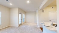 Located at 547 River Oaks Blvd in Waxahachie, TX, this single-story, one-bedroom, one-bathroom unit offers a well-organized and efficiently designed layout. The open-concept kitchen and living area form the heart of the home, with the kitchen featuring white cabinetry with brushed nickel hardware, white appliances including a range, over-the-range microwave, refrigerator, and dishwasher, as well as a peninsula with counter seating and light wood-look flooring. The living area extends naturally from the kitchen, finished with plush neutral carpet and multiple windows that invite natural light and outdoor views. A glass door provides direct exterior access from the living room, adding convenience and openness to the space. The bedroom is a comfortable, well-proportioned room with large windows overlooking greenery, plush carpet, and soft neutral wall tones. A dedicated walk-in closet accompanies the bedroom, offering built-in shelving and double hanging rods for ample storage. The bathroom is clean and functional, featuring a full tub-shower combination with white tile surround, wood-look flooring, and white cabinetry for additional storage. Throughout the unit, a consistent warm, neutral palette and thoughtful layout make this a practical and comfortable living space.