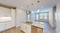 Located at 152 Market Chapel Rd in Pittsboro, NC, this single-floor, two-bedroom, two-bathroom residence offers a thoughtfully designed layout with a clean, modern aesthetic. The open-concept kitchen and living area serves as the heart of the home, showcasing granite countertop surfaces, white shaker-style cabinetry, a central island with an undermount sink, stainless steel appliances, a white subway tile backsplash, and pendant lighting — all complemented by light wood-style flooring. The living area benefits from natural light via large windows and a glass-panel door, with a ceiling fan overhead adding to the comfortable ambiance. Both bedrooms feature plush carpeting, ceiling fans, and windows that bring in natural light. The generously sized primary bedroom provides direct access to a dedicated en-suite bathroom and a walk-in closet. The primary bathroom is finished with a double-sink granite vanity, wood-style flooring, and a glass-enclosed tile shower. The second bathroom is equipped with a tub-shower combination finished in clean white tile with chrome fixtures. Two closets provide ample storage throughout the residence, rounding out this well-appointed home in Pittsboro.