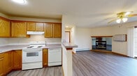 Located at 201 Air Park Dr in Watertown, Wisconsin, this single-floor, one-bedroom, one-bathroom unit offers a practical and comfortable layout with thoughtful finishes throughout. The open-concept living and dining area is a highlight of the space, featuring durable luxury vinyl plank flooring, a ceiling fan, and a corner gas fireplace framed with warm wood trim. A large sliding glass door floods the area with natural light and provides views of the surrounding green lawn. The kitchen is well-appointed with oak cabinetry, ample counter space, a full suite of white appliances including a refrigerator, electric range, and dishwasher, and a peninsula that connects it to the main living area. The generously sized bedroom is carpeted for comfort, includes a ceiling fan, a dedicated window for natural light, and access to multiple closets, including a spacious walk-in closet outfitted with built-in shelving and hanging rods. The full bathroom features oak vanity cabinetry, a lighted mirror, and a tub-shower combination with vinyl flooring. Additional conveniences include an in-unit laundry area, baseboard heating throughout, and ample closet storage. The entry foyer provides a welcoming transition into the living space.
