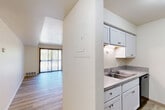 Located at 5800 Benson Dr in Haslett, Michigan, this one-bedroom, one-bathroom unit offers a thoughtfully laid-out single-floor plan. The galley-style kitchen is efficiently designed with white cabinetry, laminate countertops, a double-basin sink, a dishwasher, and a stainless steel refrigerator, all set over light wood-look flooring. The kitchen opens toward the living area, creating a connected flow throughout the main living space. The living room is bright and airy, featuring light hardwood-style flooring, a ceiling fan with light fixture, and a sliding glass door fitted with vertical blinds that leads to a private balcony, allowing natural light to fill the space. The generously sized bedroom is finished with plush wall-to-wall carpeting and a large window with vertical blinds, offering a calm and comfortable retreat. Three closets throughout the unit provide abundant storage options. The full bathroom includes a tub/shower combination, a white vanity with a laminate countertop, and wood-look tile flooring. A dedicated entrance and hallway complete the layout, offering a practical and welcoming entry to the home.