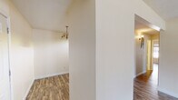 Located at 5600 Keele St in Jackson, Mississippi, this single-floor unit offers a well-organized layout with a clean, neutral aesthetic throughout. Wood-look plank flooring flows seamlessly across the main living areas and bedrooms, providing a warm and cohesive feel. The living room is generously sized, featuring a textured ceiling, a glass-panel door that invites natural light and outdoor views, and ample wall space for flexible furniture arrangements. An adjacent dining area is highlighted by a classic chandelier pendant fixture, adding a touch of character to the open transitional space. The galley-style kitchen is well-appointed with warm wood cabinetry, granite countertops, a double stainless steel sink, and a full suite of stainless steel appliances including a refrigerator, range, and built-in microwave. Light tile flooring completes the kitchen's functional and tidy design. The bedrooms are comfortably sized with wood-look flooring and windows that bring in natural light. Two bathrooms serve the unit: one full bathroom with a tub-shower combination and tile flooring, and a second bathroom with a vanity sink, large mirror, and warm lighting. Clean white walls and neutral tones throughout create a bright, move-in-ready atmosphere.