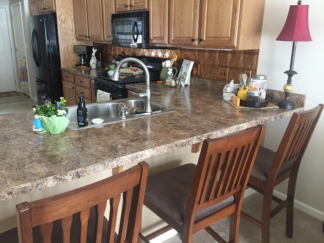Three bar stools tuck nicely under the peninsula. - 121 Touchstone Dr