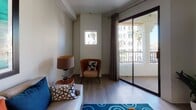 Located at 225 W Third St in downtown Long Beach, California, this one-bedroom, one-bathroom residence offers a well-designed single-floor layout that maximizes every square foot. Light wood-tone flooring flows throughout the main living areas, creating a clean and cohesive aesthetic. The open-concept kitchen is equipped with stainless steel appliances — including a gas range, microwave, and refrigerator — dark cabinetry, and a gray countertop peninsula with bar seating, making it ideal for both cooking and casual dining. The peninsula overlooks a dining area and connects seamlessly to the living room, which features recessed lighting, a small accent window, and a sliding glass door that opens to a private balcony with views of palm tree-lined streets. The bedroom is a comfortable retreat, highlighted by a bold teal accent wall, mirrored sliding closet doors, carpet flooring, and a window with natural light and outdoor views. The full bathroom includes a vanity with dark cabinetry, a tub/shower combination, and the same warm wood-tone flooring found throughout the unit. Recessed lighting and a neutral color palette give the entire residence a modern, well-maintained ambiance suited for urban living in the heart of Long Beach.