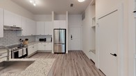 Located at 221 Wimberly St in Fort Worth, Texas, this single-story residence offers a thoughtfully designed interior with a clean, modern aesthetic throughout. The open-concept layout is anchored by a well-appointed kitchen featuring white shaker-style cabinetry, granite countertops, a classic subway tile backsplash, and a full suite of stainless steel appliances, including a French door refrigerator and a range with overhead ventilation. Light wood-tone flooring runs throughout the main living areas, contributing to a cohesive and contemporary feel.

The living area is bright and welcoming, benefiting from multiple windows that invite natural light and provide views of the surrounding greenery. A glass-paneled exterior door connects the living space to the outdoors, enhancing the sense of openness. Each bedroom is well-proportioned, featuring ceiling fans, natural light from operable windows, and light wood flooring. At least one bedroom includes a dedicated walk-in closet for added storage convenience.

The bathrooms are finished to a high standard: one features large-format taupe tile surrounding a soaking tub, a granite-topped vanity, and a wide mirror, while another showcases a frameless glass walk-in shower with coordinating tile work and matte black hardware accents. The overall ambiance is clean, neutral, and move-in ready.