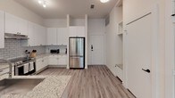 Located at 221 Wimberly St in Fort Worth, Texas, this single-story residence offers a thoughtfully designed interior with a clean, modern aesthetic throughout. The open-concept layout is anchored by a well-appointed kitchen featuring white shaker-style cabinetry, granite countertops, a classic subway tile backsplash, and a full suite of stainless steel appliances, including a French door refrigerator and a range with overhead ventilation. Light wood-tone flooring runs throughout the main living areas, contributing to a cohesive and contemporary feel.

The living area is bright and welcoming, benefiting from multiple windows that invite natural light and provide views of the surrounding greenery. A glass-paneled exterior door connects the living space to the outdoors, enhancing the sense of openness. Each bedroom is well-proportioned, featuring ceiling fans, natural light from operable windows, and light wood flooring. At least one bedroom includes a dedicated walk-in closet for added storage convenience.

The bathrooms are finished to a high standard: one features large-format taupe tile surrounding a soaking tub, a granite-topped vanity, and a wide mirror, while another showcases a frameless glass walk-in shower with coordinating tile work and matte black hardware accents. The overall ambiance is clean, neutral, and move-in ready.