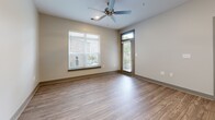 Located in Murfreesboro, TN, this 2-bedroom, 2-bathroom residence offers a thoughtfully designed single-level floor plan with modern finishes throughout. The open-concept kitchen and living area serves as the heart of the home, where white shaker cabinetry, granite countertops, and stainless steel appliances — including a refrigerator, dishwasher, and range — create a clean, functional workspace. Pendant lighting above the counter and wood-look luxury vinyl plank flooring extend seamlessly into the living area, which features a ceiling fan and access to an outdoor area through a glass-paneled door, allowing natural light to fill the space. Both bedrooms are carpeted and equipped with ceiling fans, offering a comfortable and quiet retreat. The primary bedroom includes a dedicated walk-in closet outfitted with multi-tier wire shelving for ample storage. The two bathrooms are finished with marble-look porcelain tile on both the floors and walls. The primary bath features a soaking tub with a full tiled surround, while the second bath offers a glass-enclosed walk-in shower. Both bathrooms include granite-topped vanities with white cabinetry. A dedicated laundry area with wood-look flooring and a thermostat rounds out this well-planned residence.