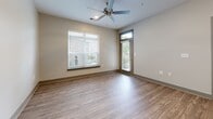 Located in Murfreesboro, TN, this 2-bedroom, 2-bathroom residence offers a thoughtfully designed single-level floor plan with modern finishes throughout. The open-concept kitchen and living area serves as the heart of the home, where white shaker cabinetry, granite countertops, and stainless steel appliances — including a refrigerator, dishwasher, and range — create a clean, functional workspace. Pendant lighting above the counter and wood-look luxury vinyl plank flooring extend seamlessly into the living area, which features a ceiling fan and access to an outdoor area through a glass-paneled door, allowing natural light to fill the space. Both bedrooms are carpeted and equipped with ceiling fans, offering a comfortable and quiet retreat. The primary bedroom includes a dedicated walk-in closet outfitted with multi-tier wire shelving for ample storage. The two bathrooms are finished with marble-look porcelain tile on both the floors and walls. The primary bath features a soaking tub with a full tiled surround, while the second bath offers a glass-enclosed walk-in shower. Both bathrooms include granite-topped vanities with white cabinetry. A dedicated laundry area with wood-look flooring and a thermostat rounds out this well-planned residence.