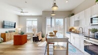 Located on Richmond's iconic Monument Avenue, this thoughtfully designed one-bedroom, one-bathroom residence offers a comfortable and modern living experience. The open-concept layout seamlessly connects the kitchen and living room, creating an inviting, airy atmosphere throughout.

The kitchen is a standout feature, showcasing crisp white shaker cabinetry, granite countertops, a subway tile backsplash, and a full suite of stainless steel appliances including a range, microwave, and refrigerator. Pendant lights with an industrial flair hang above a granite-topped kitchen island with bar seating, perfect for casual dining. A sliding glass door floods the space with natural light and provides outdoor access.

The living room is bright and welcoming, with large windows offering outdoor views and a ceiling fan overhead. Light-toned hardwood-style flooring runs throughout the main living areas, adding warmth and continuity.

The bedroom is a serene retreat, carpeted for comfort, with a generous window that brings in ample natural light. The bathroom features a white vanity with granite countertops, a large mirror, and hardwood-style flooring. An adjacent walk-in closet provides convenient storage. The overall ambiance of the residence is clean, modern, and move-in ready.