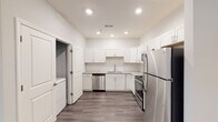Located in Burlington, NC, this single-floor unit offers a thoughtfully designed layout with modern finishes and a clean, contemporary aesthetic. The kitchen is a standout feature, outfitted with crisp white shaker-style cabinetry, light stone countertops, and a full suite of stainless steel appliances including a refrigerator, range, and dishwasher. Wood-look plank flooring runs throughout the kitchen and main living areas, lending warmth and continuity to the space. The bedrooms are finished with soft wall-to-wall carpeting in a neutral tone, complemented by light blue-gray walls that create a calm and restful atmosphere. Each bedroom includes ceiling fans and features generous closet space with double-door configurations. Natural light filters in through windows with blinds, offering views of the surrounding neighborhood. The bathroom is finished in a clean, all-white palette, featuring a full soaking tub with overhead shower, chrome fixtures, and a vanity with a light stone countertop and large mirror. Throughout the unit, white panel doors, recessed lighting, and consistent neutral tones contribute to a cohesive and move-in-ready environment well-suited for comfortable everyday living.