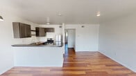 Located at 1408 Hughes St in Houston, TX, this one-bedroom, one-bathroom unit offers a well-organized single-floor layout designed for comfortable everyday living. Warm hardwood-style flooring runs throughout the main living areas, lending a cohesive and inviting feel to the entire space.

The open kitchen and living room combination serves as the heart of the unit. The kitchen is outfitted with gray shaker-style cabinetry, a warm wood-tone countertop, a stainless steel gas range, stainless steel refrigerator, and a peninsula with a gray countertop that doubles as a breakfast bar. A pendant light and recessed track lighting illuminate the kitchen area, while a large window and sliding door flood the adjoining living room with natural light.

The bedroom is a well-proportioned retreat featuring hardwood-style flooring, a ceiling fan with integrated lighting, a natural light source from a dedicated window, and access to two closets, providing ample storage. A hallway connects the bedroom to the rest of the unit, maintaining a logical and private flow.

The full bathroom is clean and functional, featuring a single-sink vanity with wood cabinetry, a wall mirror, and a combined shower and soaking tub. White walls and fixtures throughout the unit create a bright, neutral backdrop that is easy to personalize.