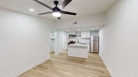 Located at 2875 Palumbo Dr in Lexington, KY, this thoughtfully designed one-bedroom, one-bathroom unit offers a clean, modern aesthetic across a single floor. Light hardwood-style flooring flows throughout the main living areas, complemented by crisp white walls and recessed lighting that create a bright, airy atmosphere. A ceiling fan anchors the open living room, which connects seamlessly to the kitchen and benefits from a window that brings in natural light.

The kitchen is a standout feature, boasting granite countertops, a central island for added prep and dining space, white shaker cabinetry with matte black hardware, a classic subway tile backsplash, and a full suite of stainless steel appliances including a range, microwave, dishwasher, and refrigerator.

The bedroom offers a comfortable, carpeted retreat with its own ceiling fan, a window with outdoor views, and a wall-mounted mini-split HVAC unit. A dedicated closet provides ample storage. The bathroom is finished in a modern style with white cabinetry, a tub-shower combination, and matte black fixtures throughout.

A separate laundry room houses a full-size washer and dryer, adding everyday convenience. The unit's cohesive design, quality finishes, and practical layout make it an efficient and attractive living space.