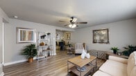 Located at 1912 Green Mountain Dr in Little Rock, AR, this one-bedroom, one-bathroom residence offers a thoughtfully designed single-floor layout. The open living and dining area is anchored by a classic fireplace and ceiling fan with light fixture, complemented by wood-style plank flooring that flows throughout the entire space. A bright window allows natural light to fill the living room, enhancing the clean, neutral palette of the walls and trim. The adjoining dining area accommodates an intimate table setting and is adorned with framed artwork, creating a polished atmosphere. The galley-style kitchen features dark espresso cabinetry, granite-style countertops, a double sink, and black appliances, offering generous storage and prep space. The bedroom is a comfortable retreat, highlighted by a ceiling fan, a large window with blinds, and ample room for full furniture arrangements. It connects directly to a walk-in closet equipped with wire shelving for organized storage. The bathroom mirrors the kitchen's design aesthetic with dark cabinetry, a granite-style vanity countertop, an extended mirror, and a shower-tub combination. A hallway connects the rooms efficiently, completing this cohesive and functional floor plan.